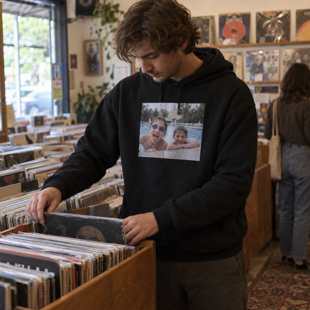 A black photo hoodie printed with an old poolside snapshot of siblings in a record shop.