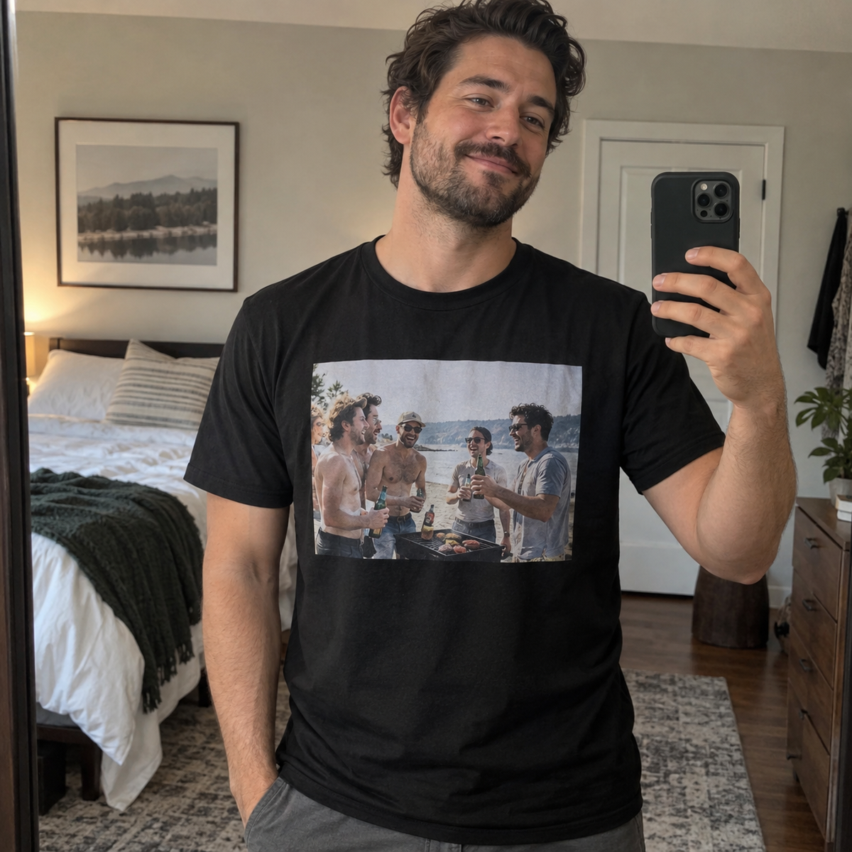 A black T-shirt printed with a past friends' beach barbecue photo, shown in a casual mirror selfie.