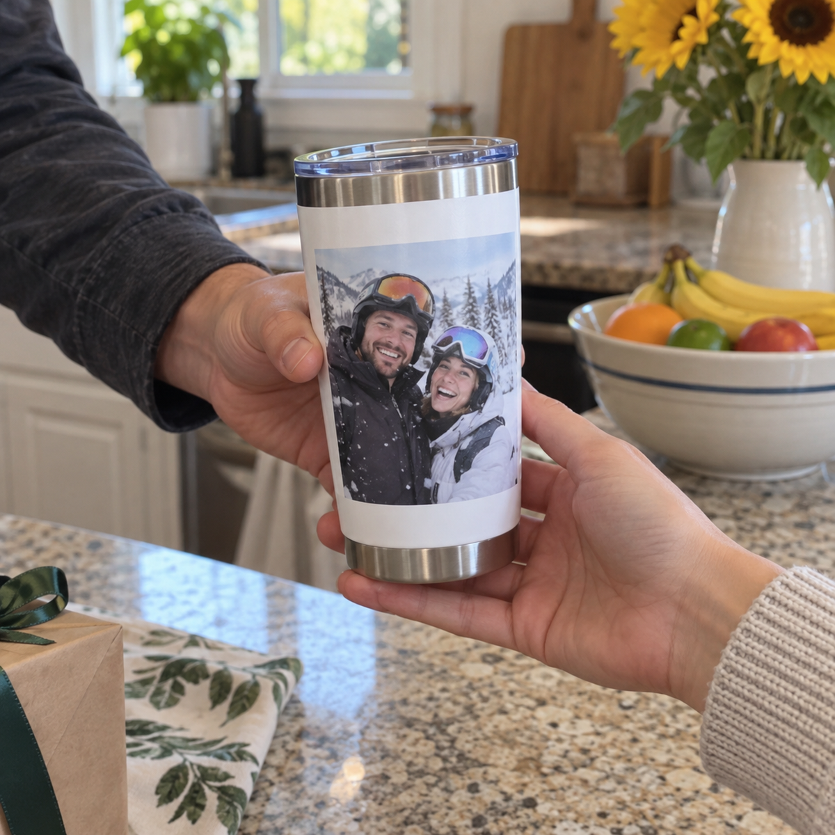 A personalized stainless travel tumbler printed with a winter skiing photo of a couple, given as a gift in a kitchen.