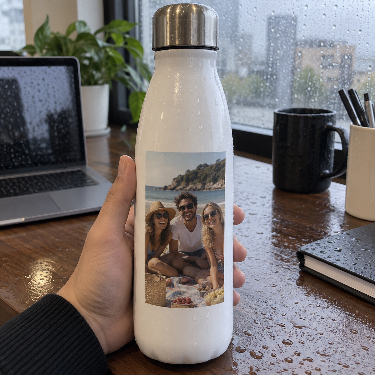 An insulated bottle printed with an old summer picnic photo on an office desk.