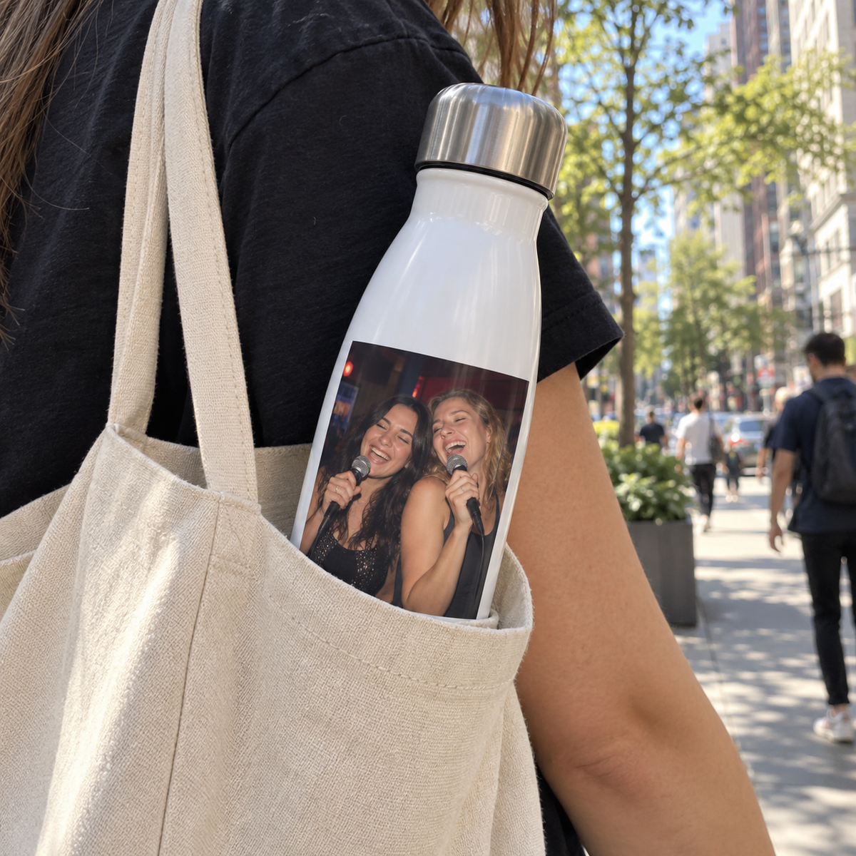 A white insulated bottle printed with a past karaoke photo, carried through the city.