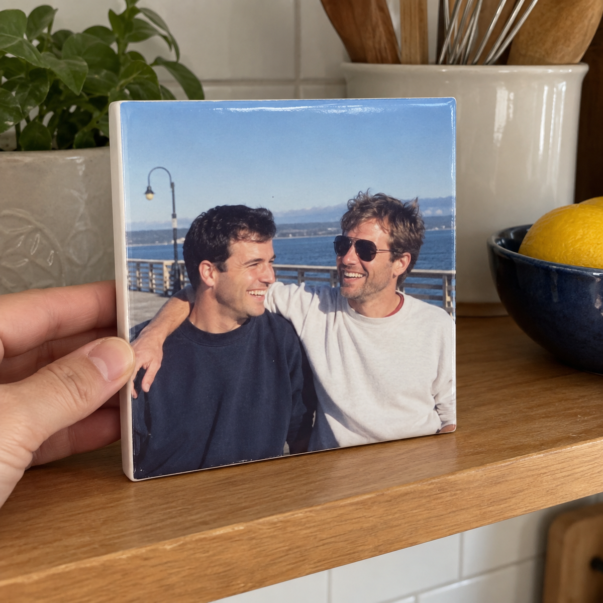 Ceramic photo tile with two brothers on a pier in a kitchen.