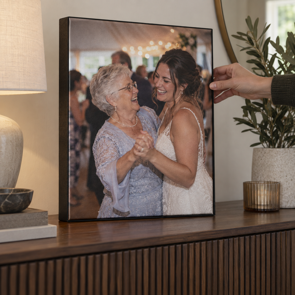 A framed canvas print showing a grandmother dancing with her granddaughter at a wedding.