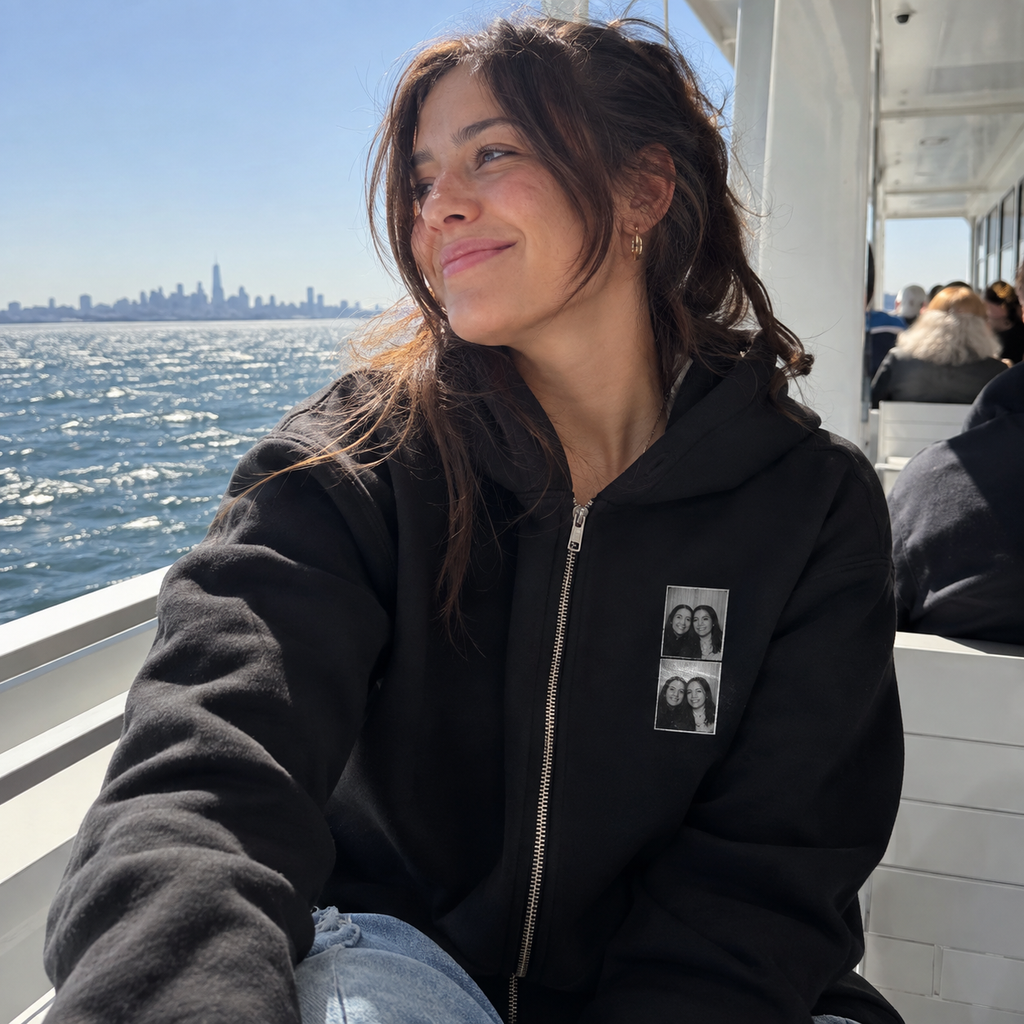 Black zip hoodie with a small photo booth strip on its left chest.