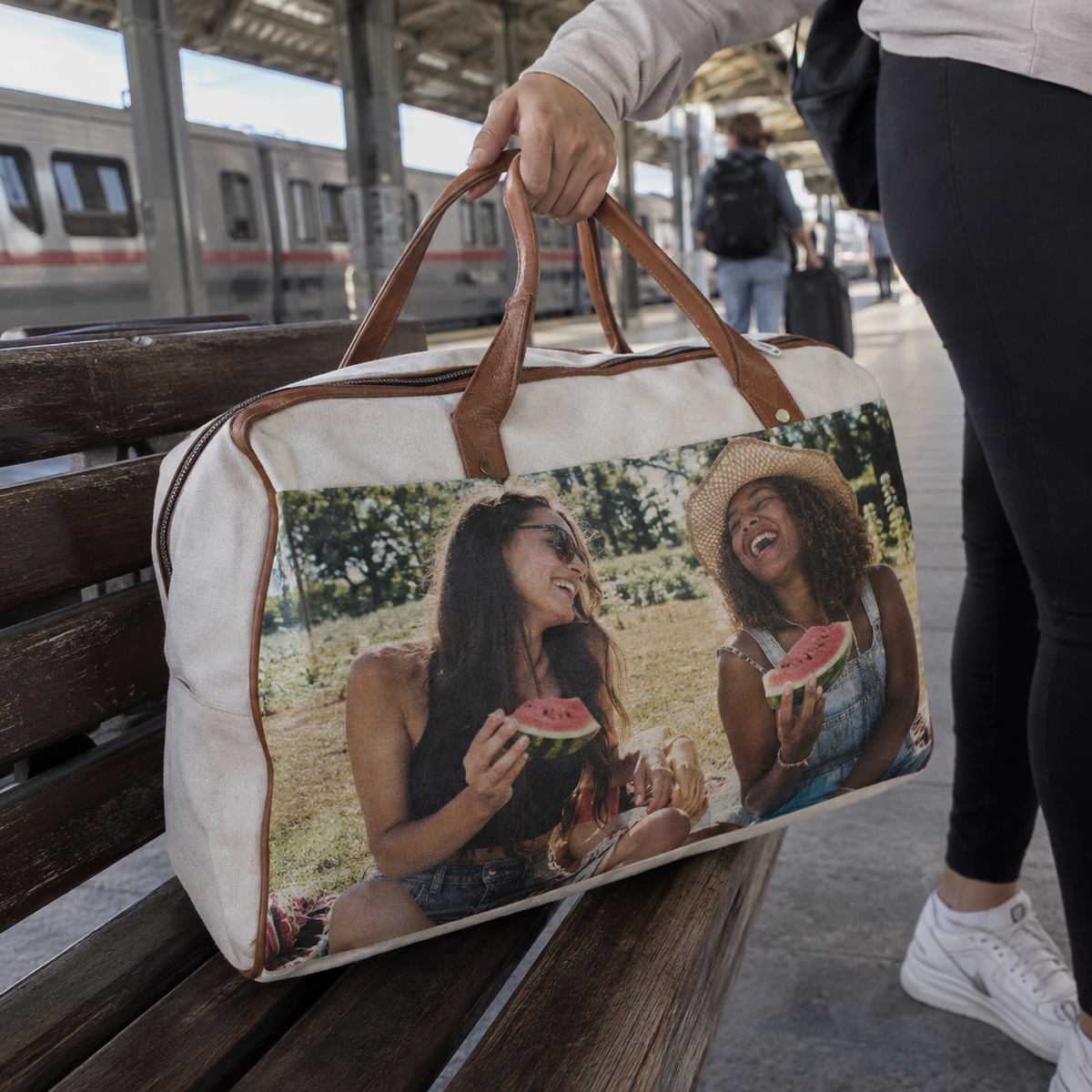 A weekender bag printed with a summer picnic photograph at a station.