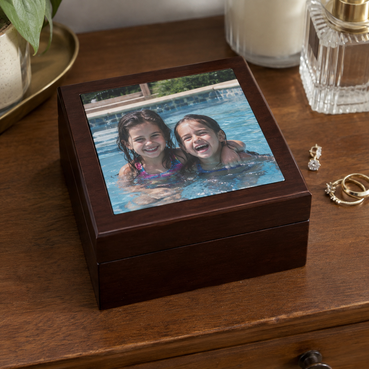 A dark wood jewelry box with a childhood photo on its closed lid.