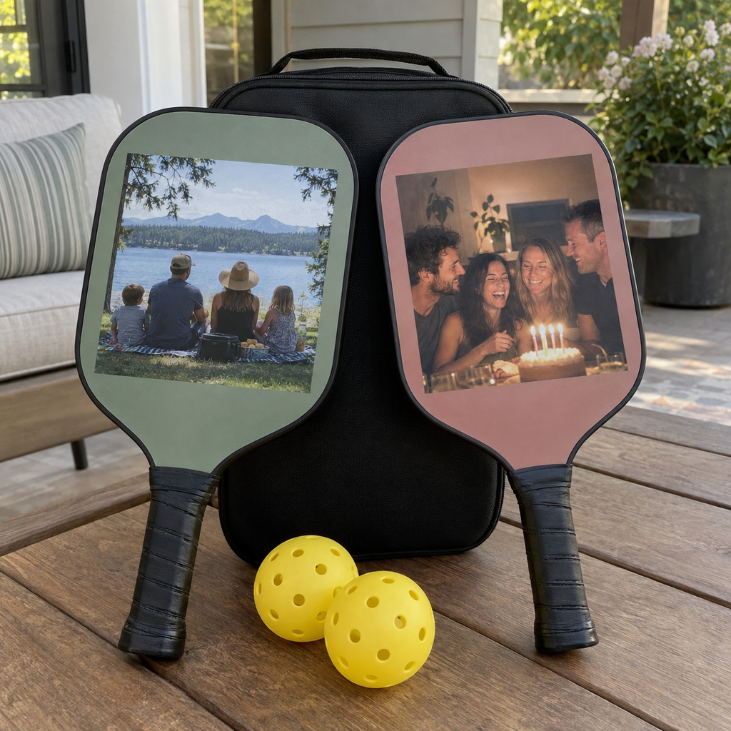 Two personalized pickleball paddles printed with different family and birthday photos, beside a carry case.