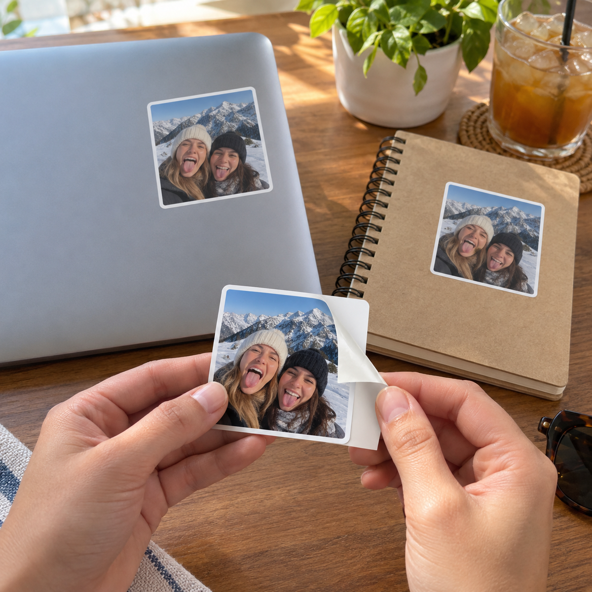 Matching personalized photo stickers printed with two friends on a ski holiday, applied to a laptop and notebook.
